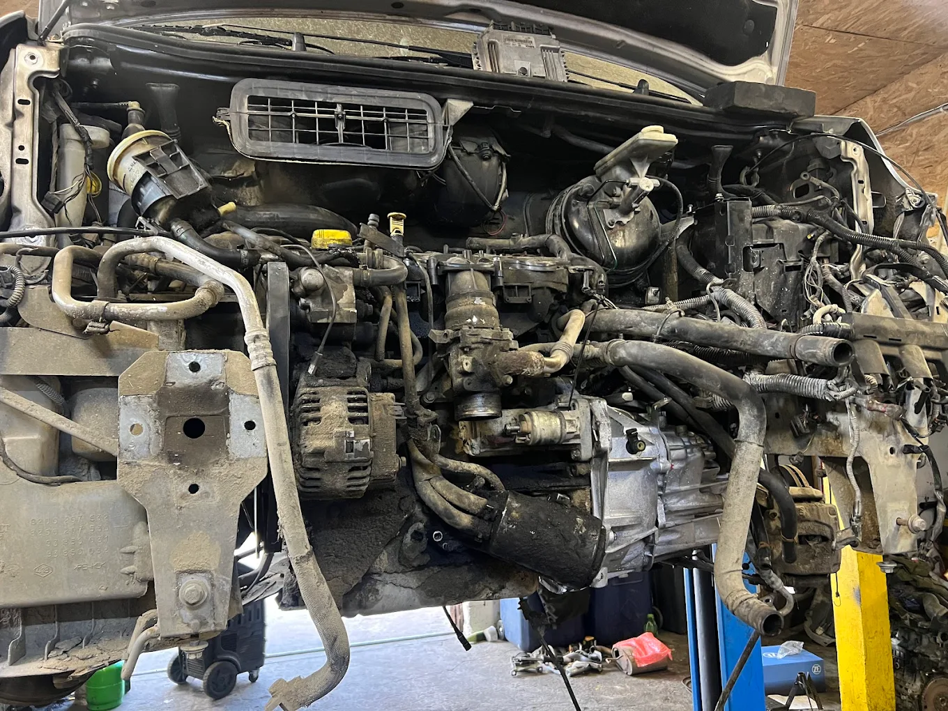 Silnik i osprzęt samochodu po demontażu przedniego pasa podczas większej naprawy.